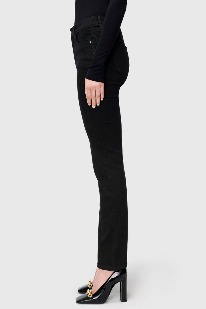 Person wearing black jeans and high heels on a white background