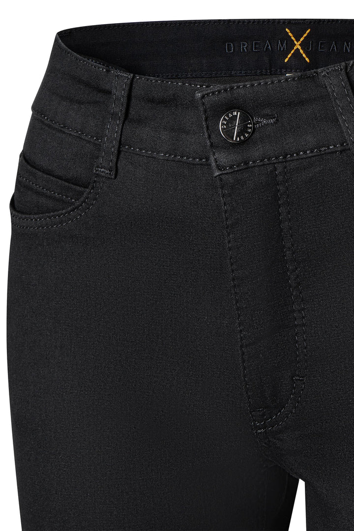 Close-up of black jeans with a brand logo on the pocket.