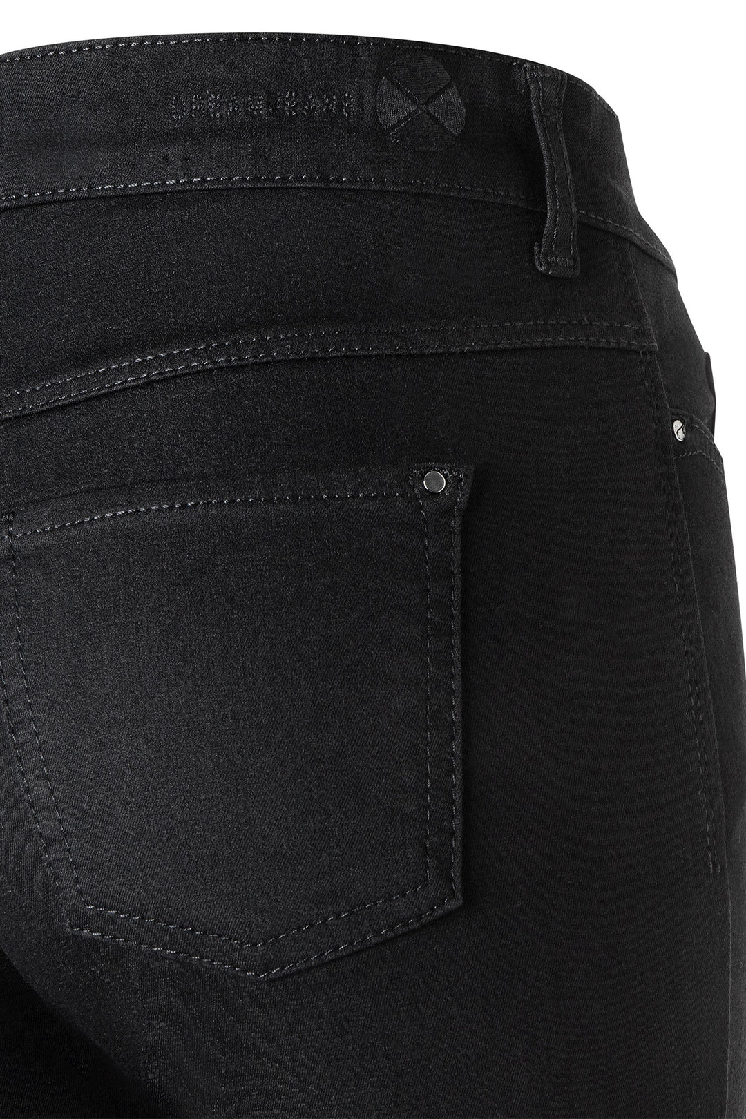 Close-up of black jeans with a visible brand label on a white background