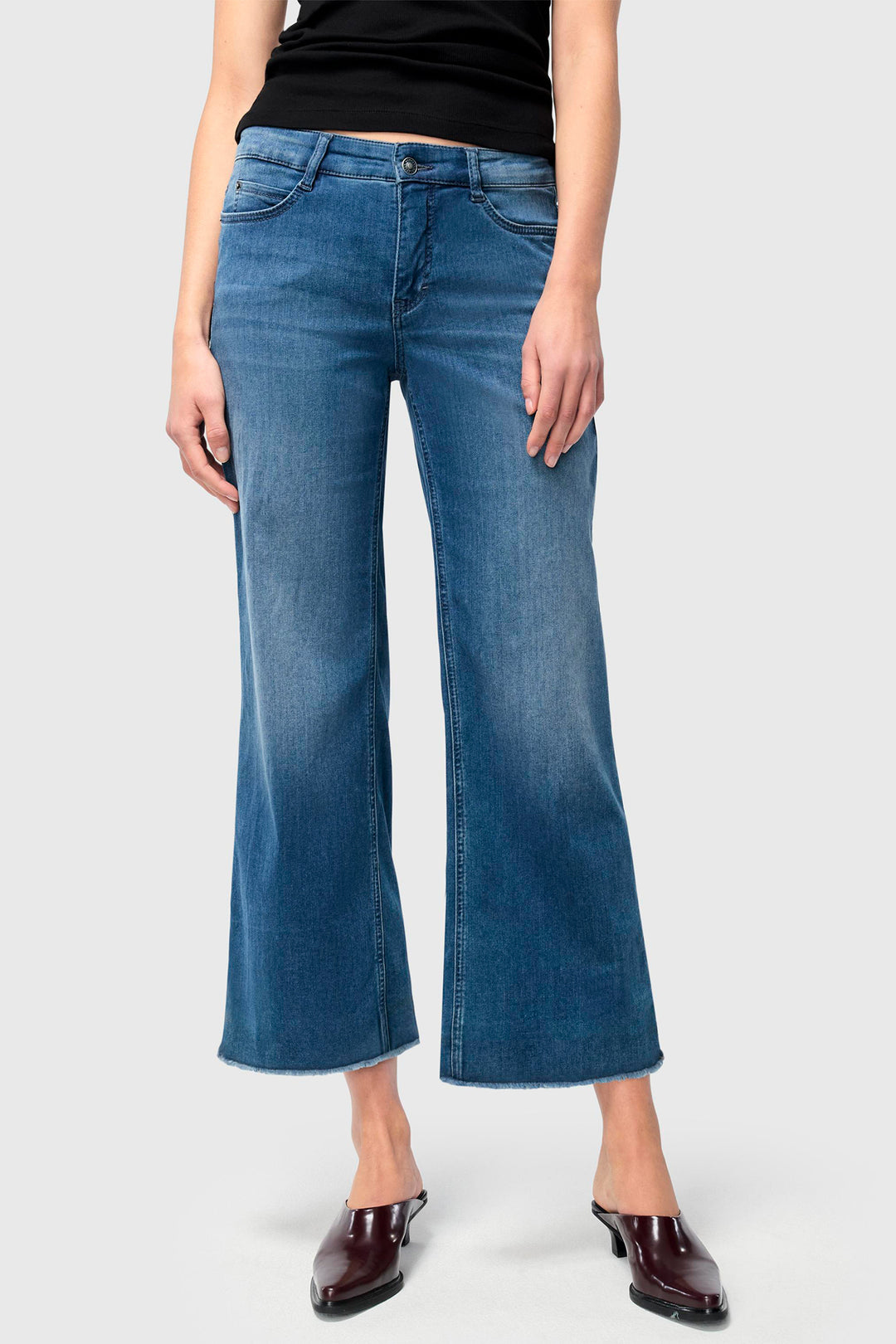 Person wearing blue jeans on a white background