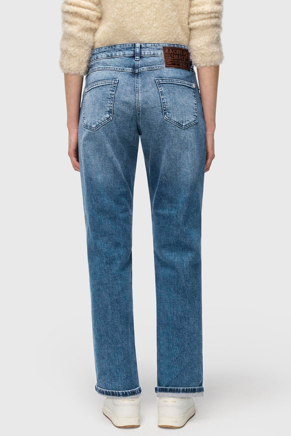 Person wearing blue jeans with a white background