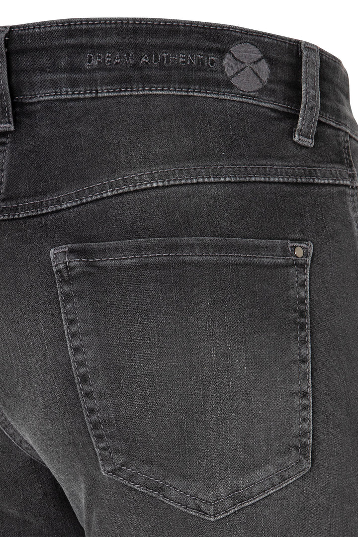 Close-up of black jeans with a brand logo on the back pocket.