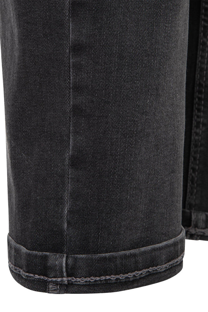 Close-up of black denim shorts with visible stitching on a white background