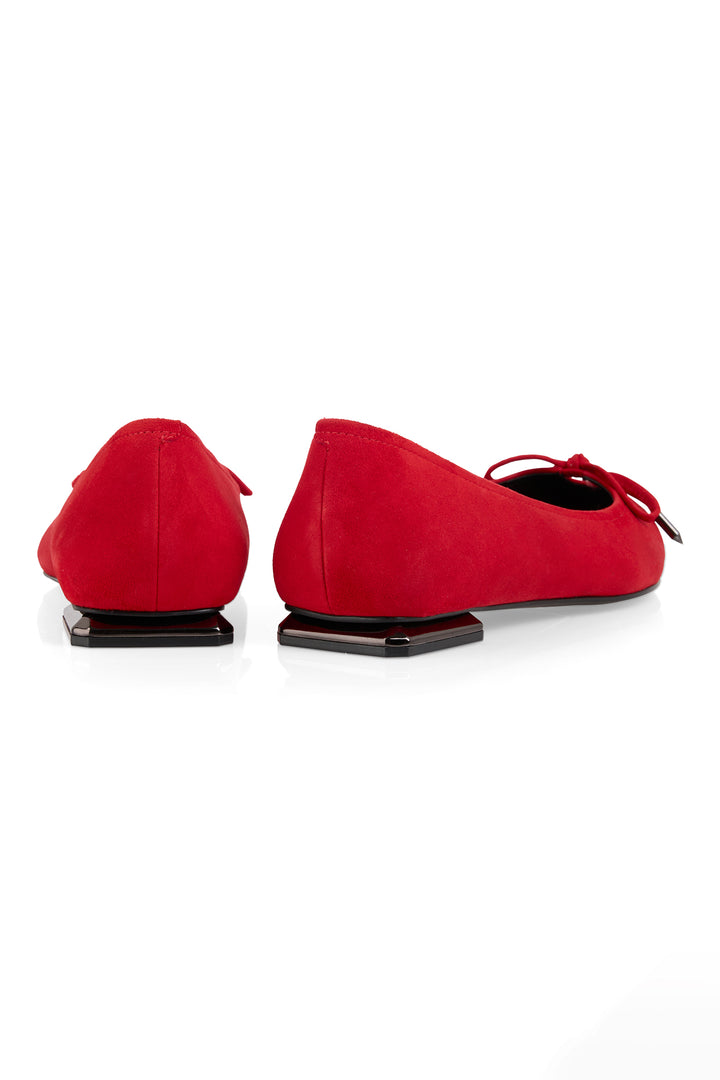 Red suede shoes with a bow on a white background