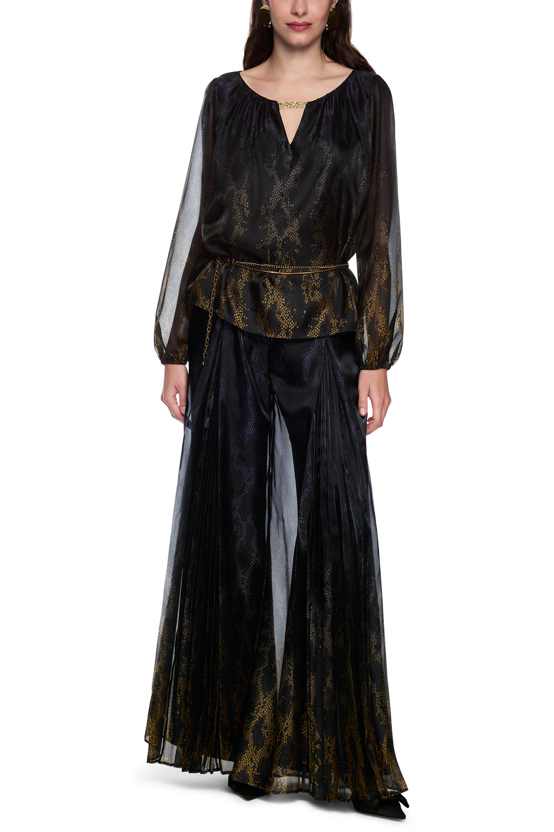 Woman wearing a black and gold patterned dress on a white background