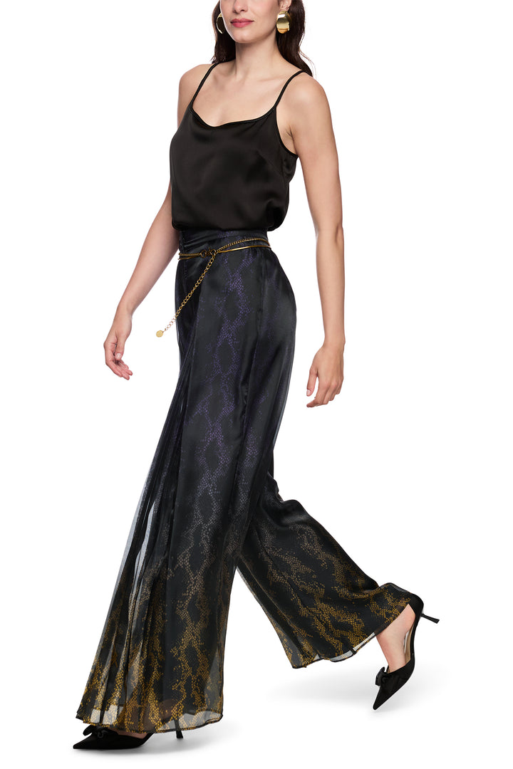 Woman wearing a black top and patterned pants on a white background