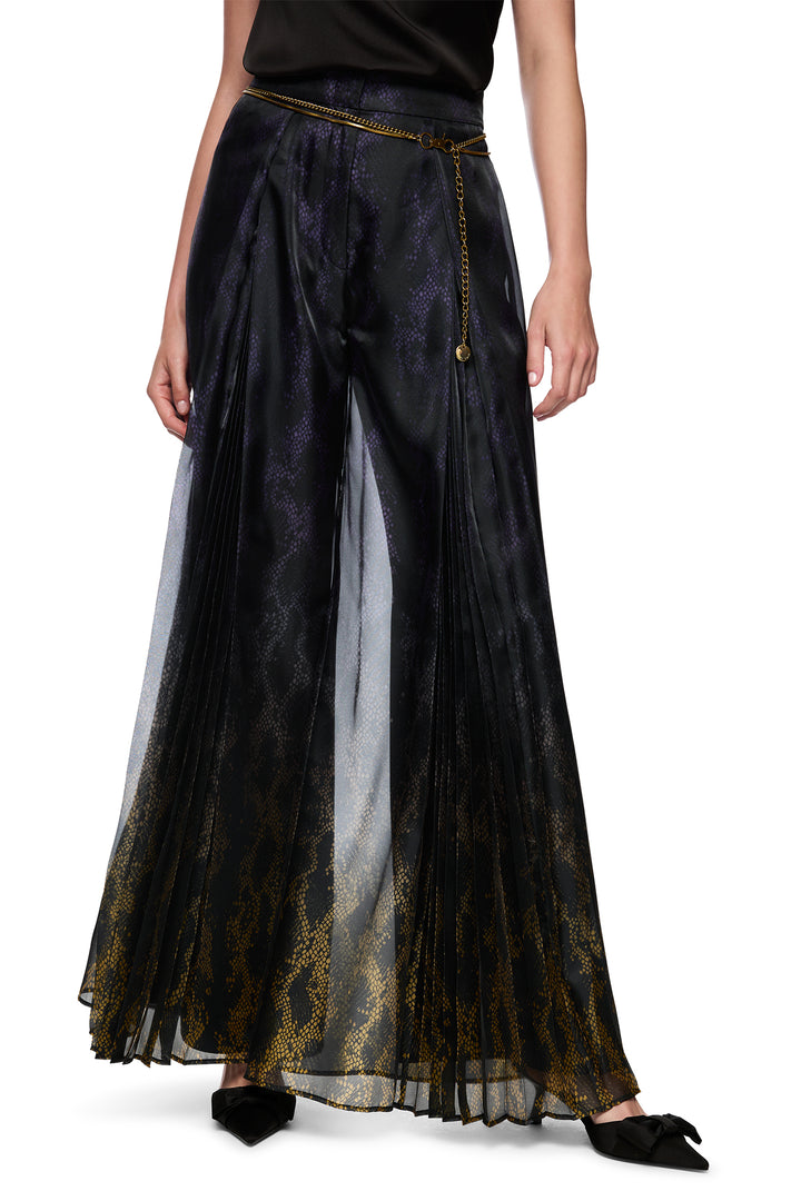 Black pleated skirt with sheer overlay worn by a person on a white background