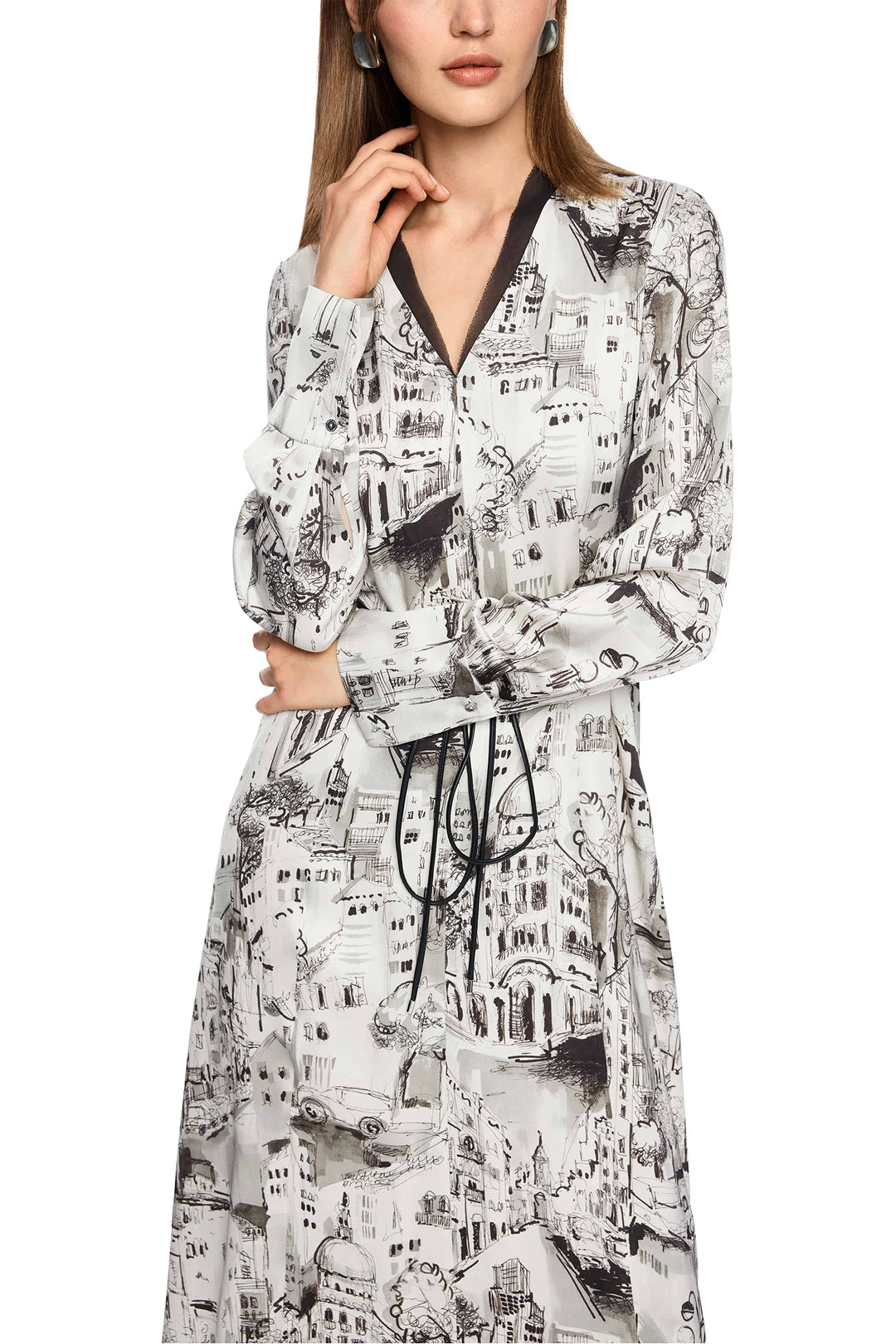 Woman wearing a long-sleeve dress with a black and white cityscape print.