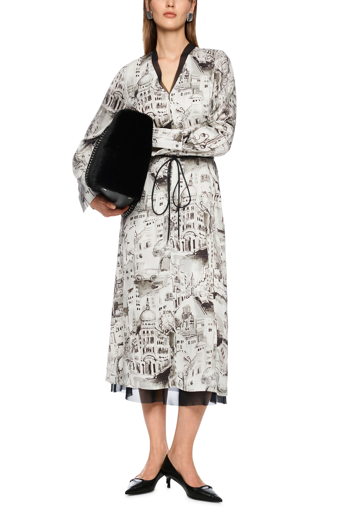 Woman wearing a patterned dress with a black clutch on a white background