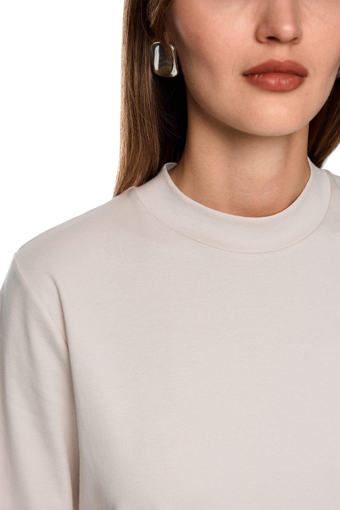 Close-up of a person wearing a light gray sweater on a white background