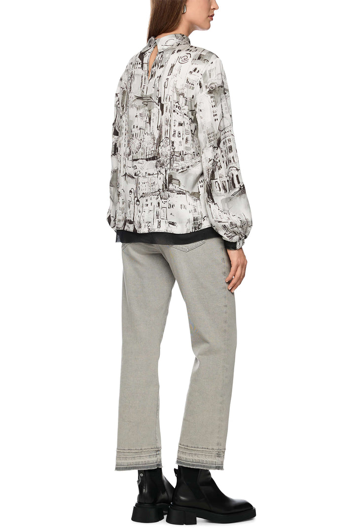 Person wearing a patterned jacket and light gray pants on a white background