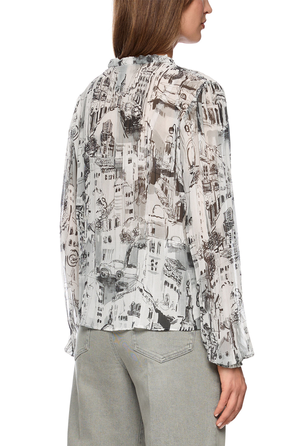 Woman wearing a patterned blouse with long sleeves on a white background
