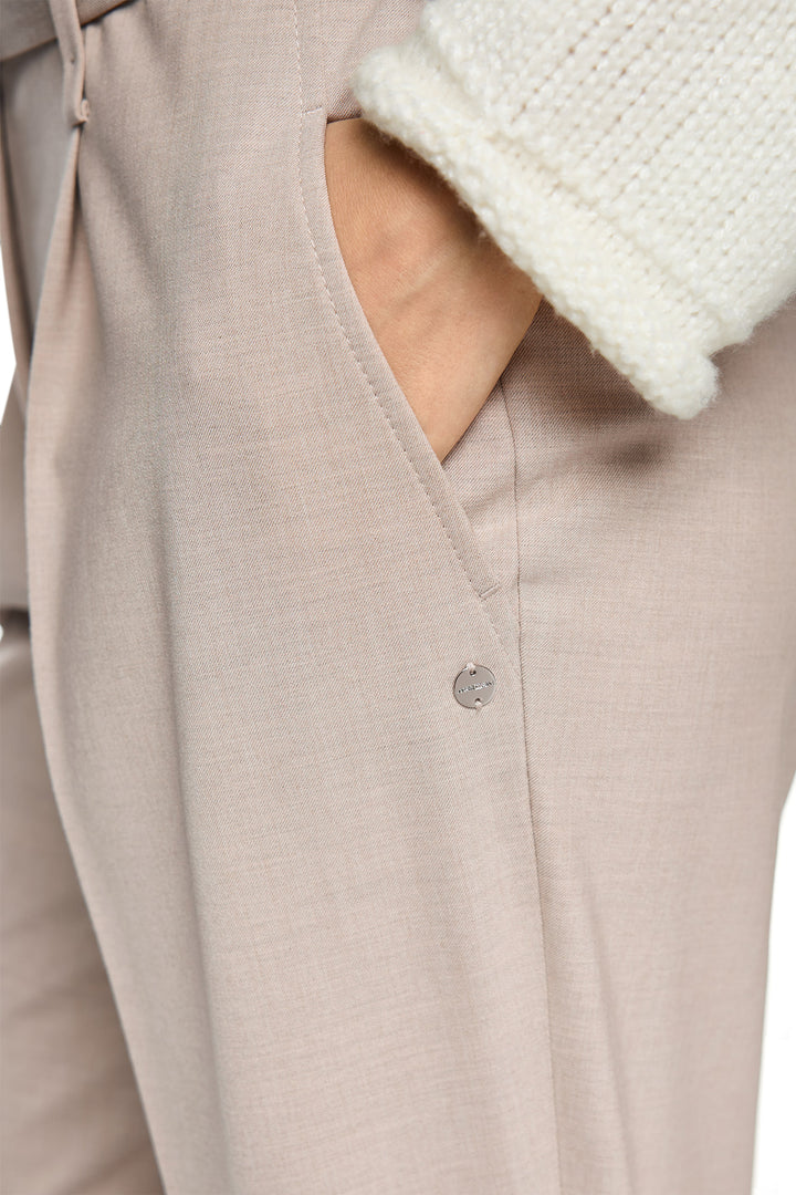 Close-up of a beige garment with white fur trim on a white background