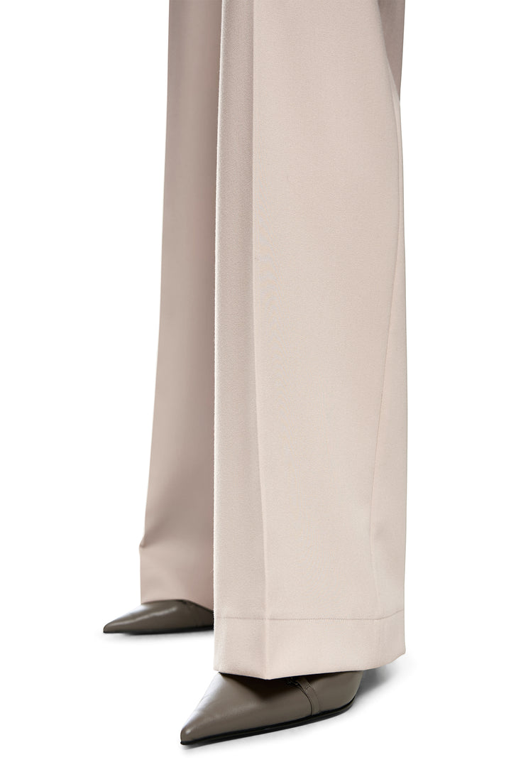 Beige pants worn by a person on a white background