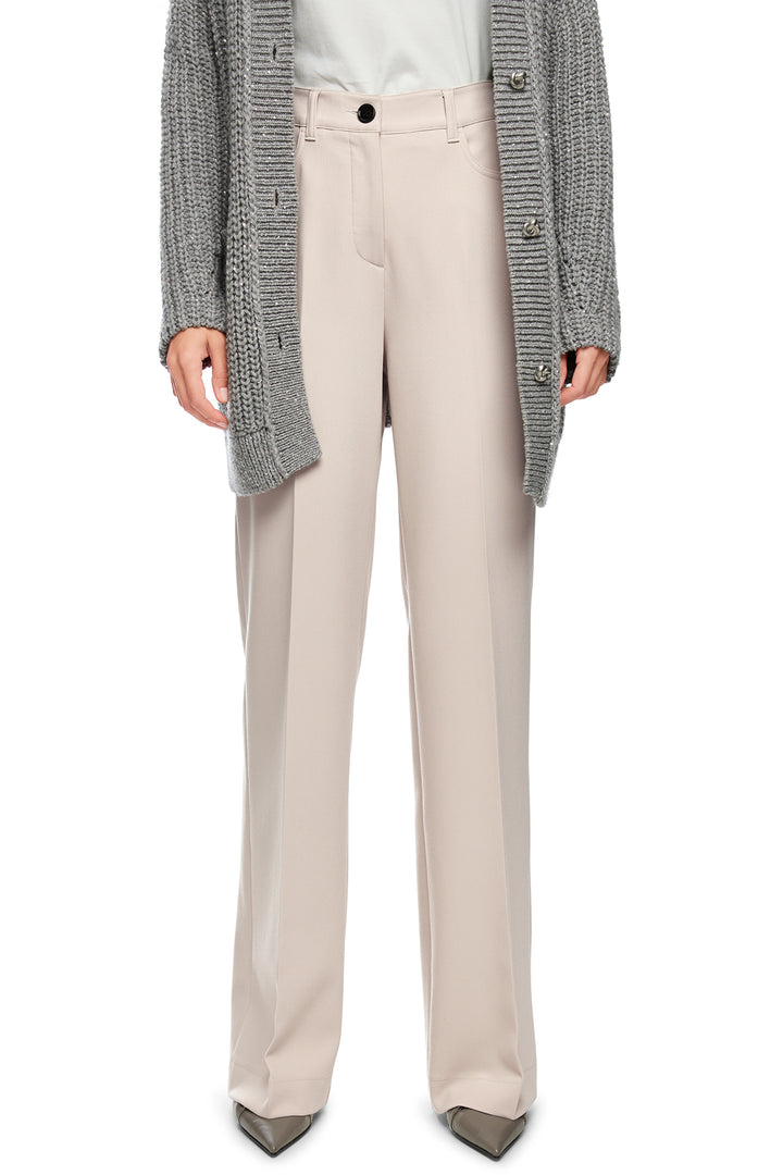 Person wearing beige pants with a gray cardigan on a white background