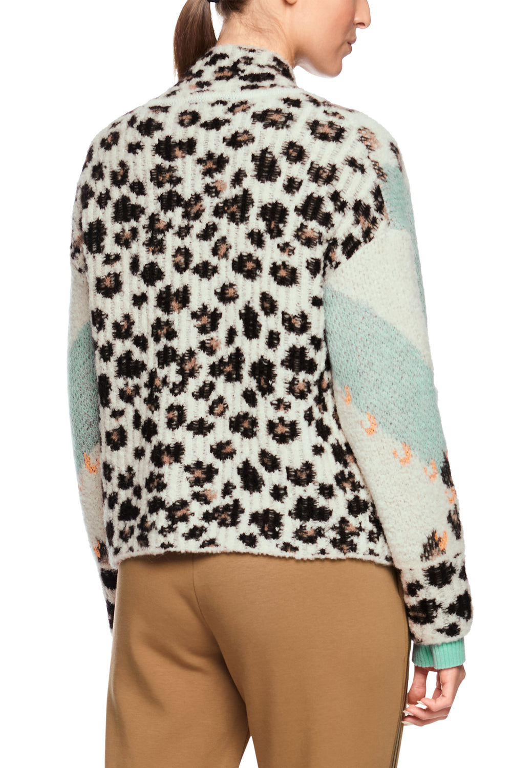 Person wearing a patterned sweater with a leopard print design on a white background
