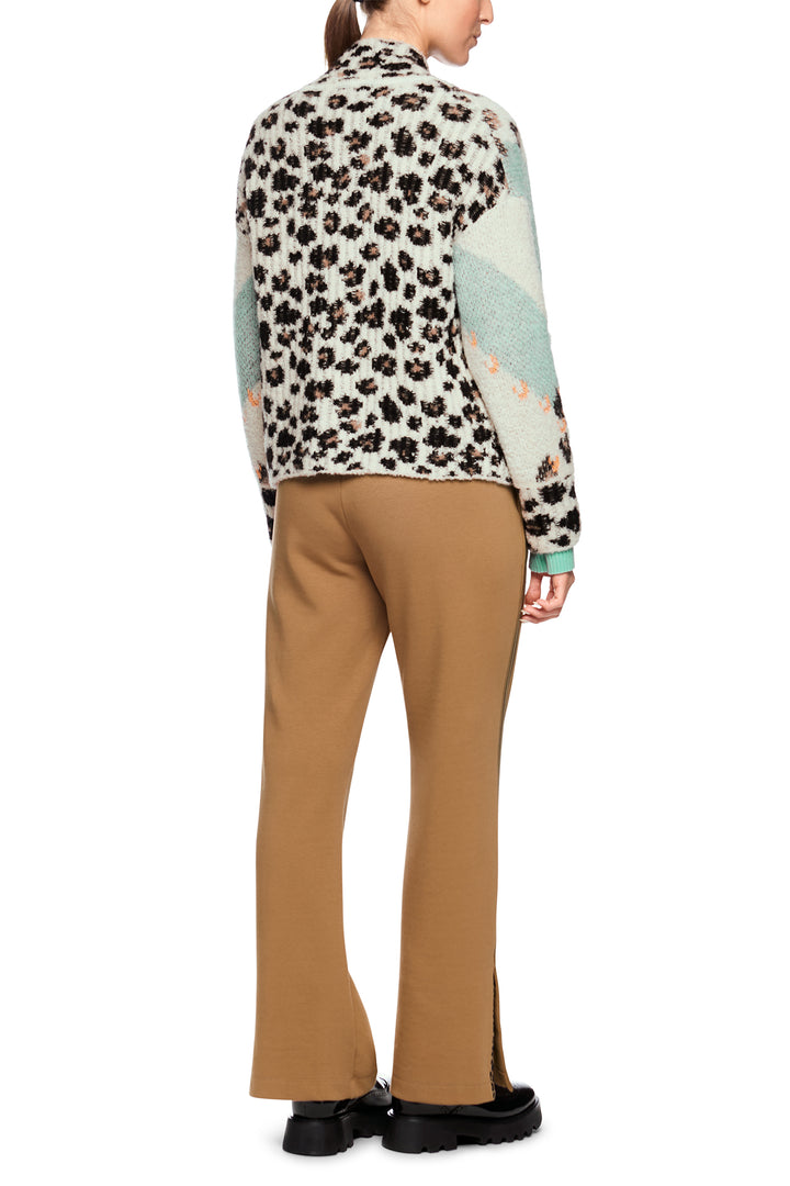 Person wearing a patterned shirt and tan pants on a white background