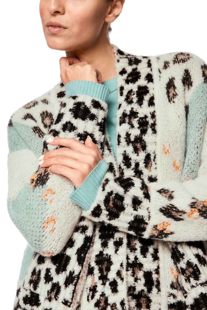 Person wearing a leopard print cardigan with light blue sleeves