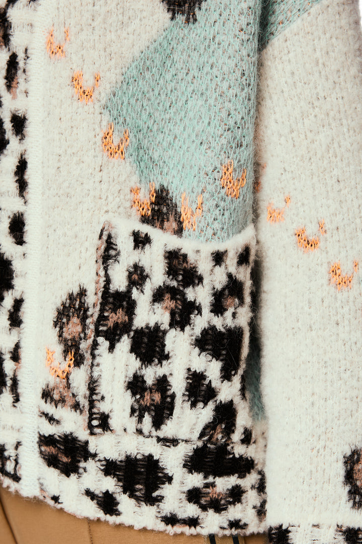 Close-up of a textured fabric with leopard print pattern and orange accents.