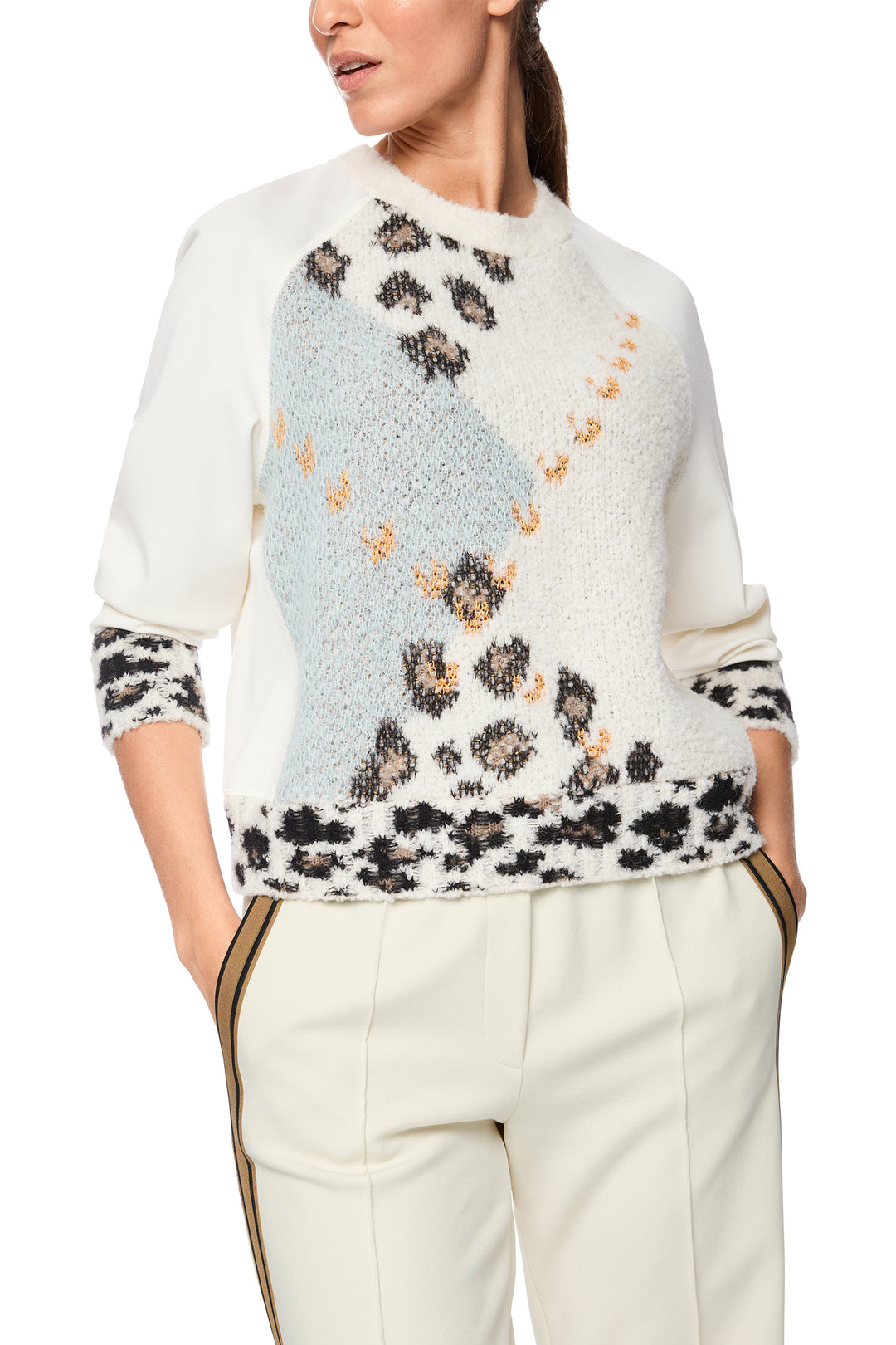Woman wearing a white sweater with floral pattern on a white background