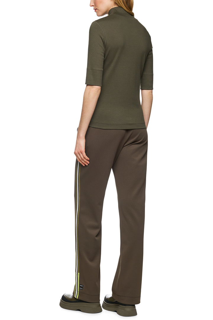 Person wearing a green top and brown pants with white stripes on a white background