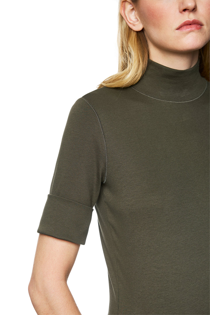 Close-up of a person wearing an olive green turtleneck sweater on a white background