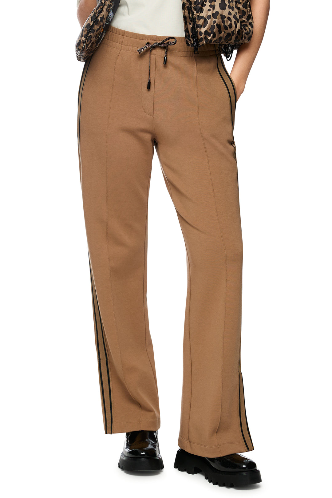 Tan pants with black trim worn by a person on a white background
