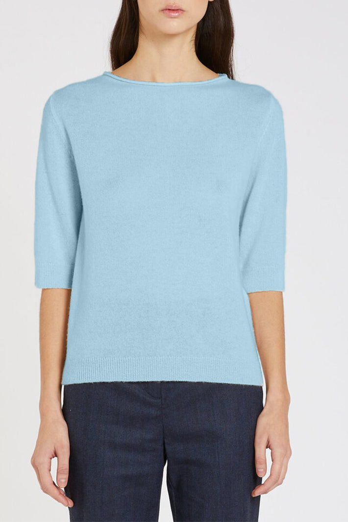 Light blue sweater worn by a person on a plain background