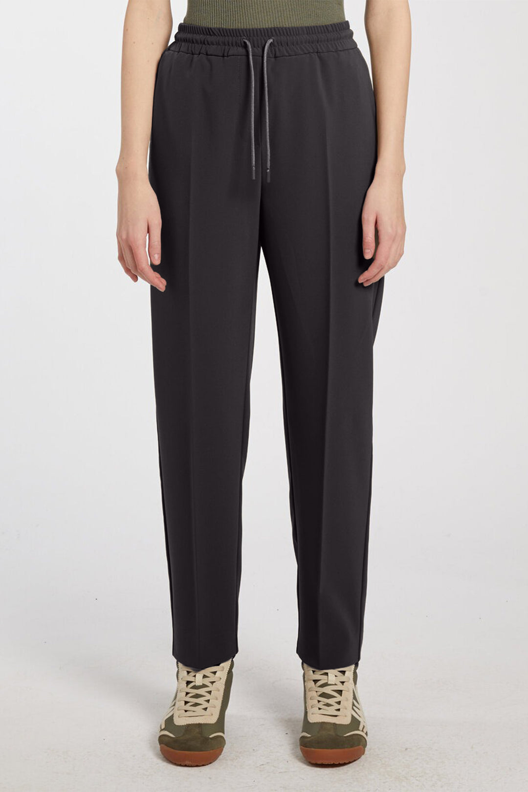 Person wearing black pants on a white background