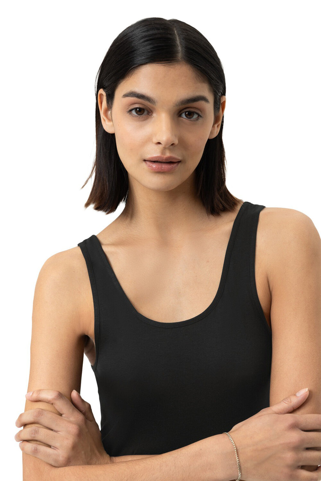 Woman wearing a black tank top against a white background