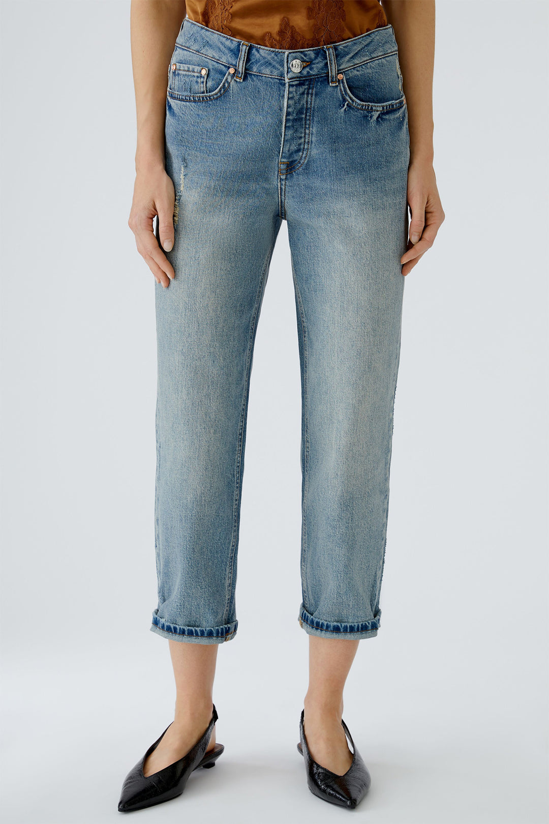 Person wearing light blue jeans on a plain background