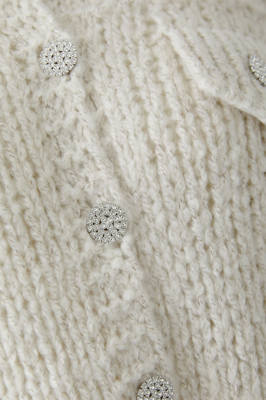 Close-up of a textured fabric with decorative buttons.