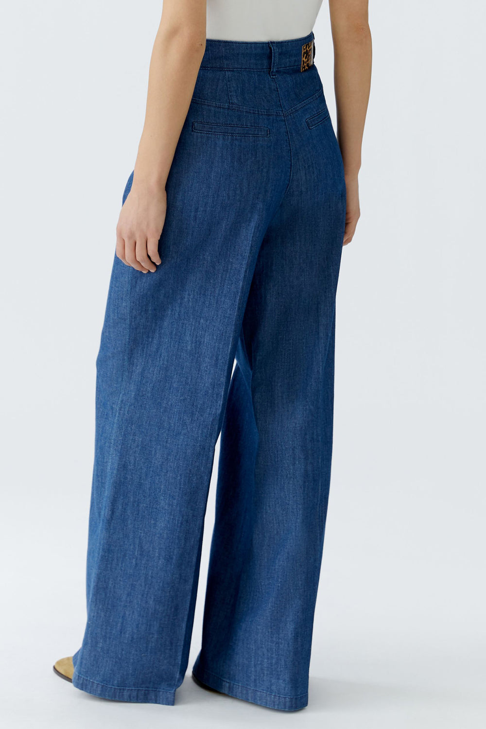 Person wearing blue wide-leg jeans on a white background
