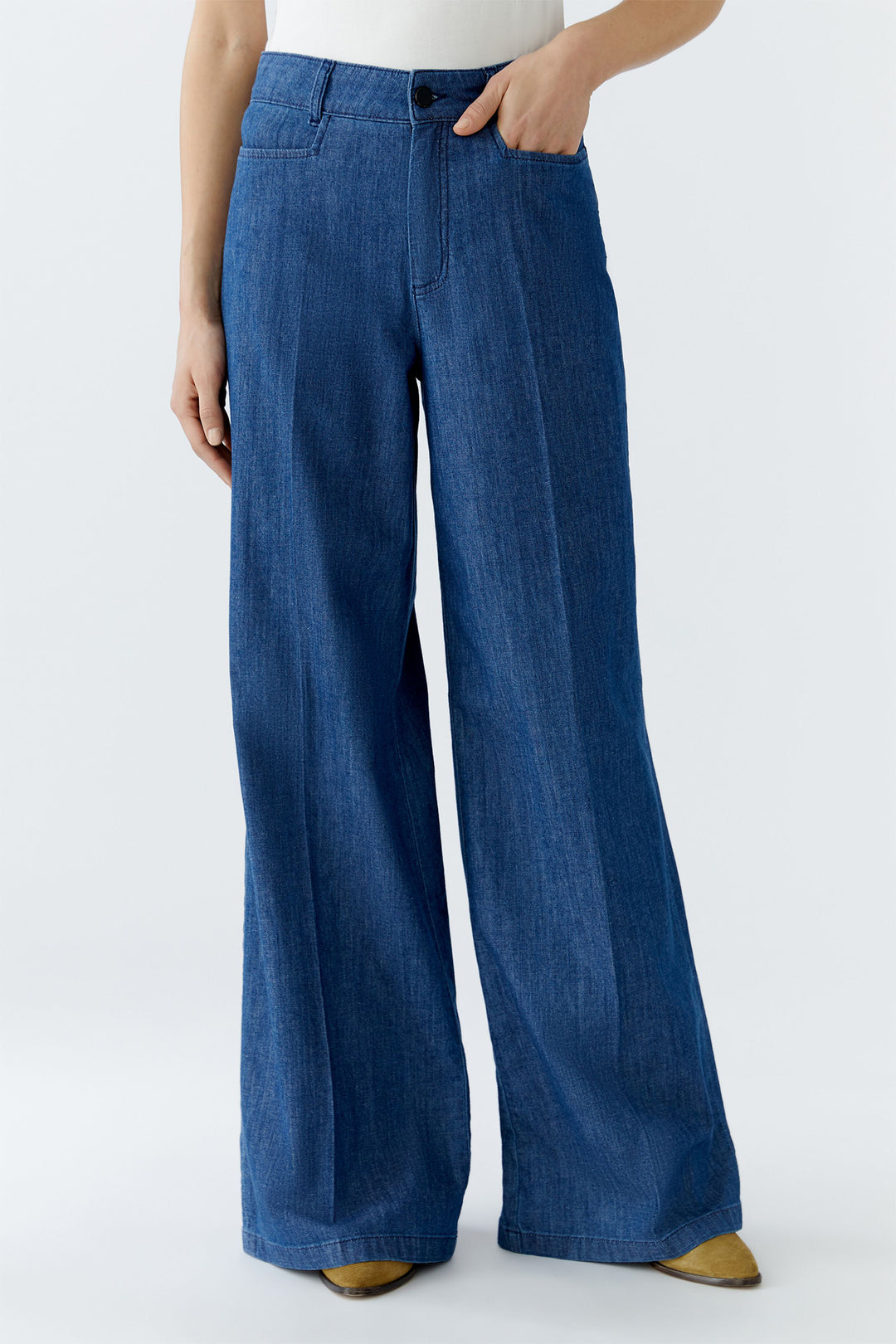 Person wearing blue wide-leg jeans on a white background