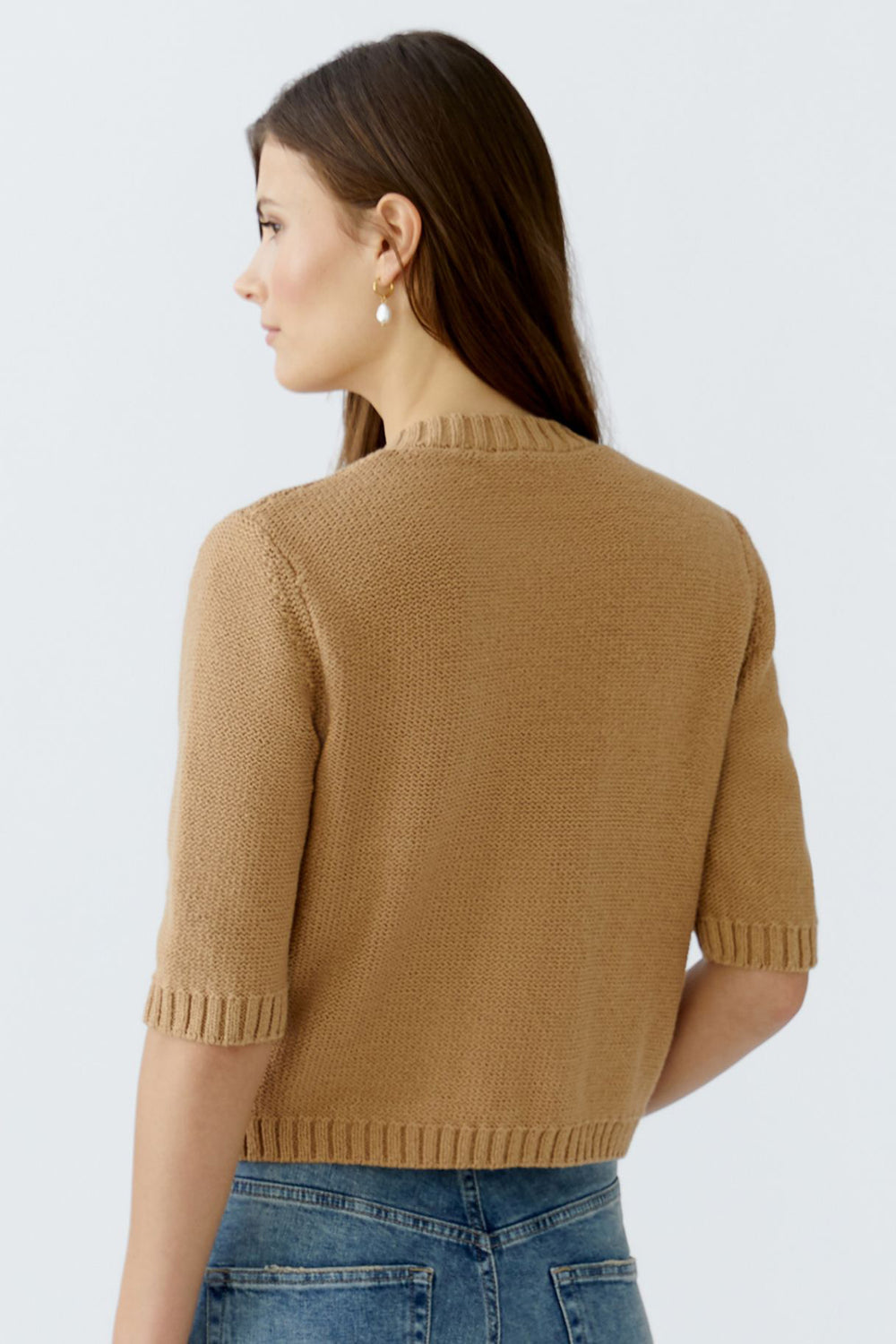 Woman wearing a brown knitted sweater on a white background