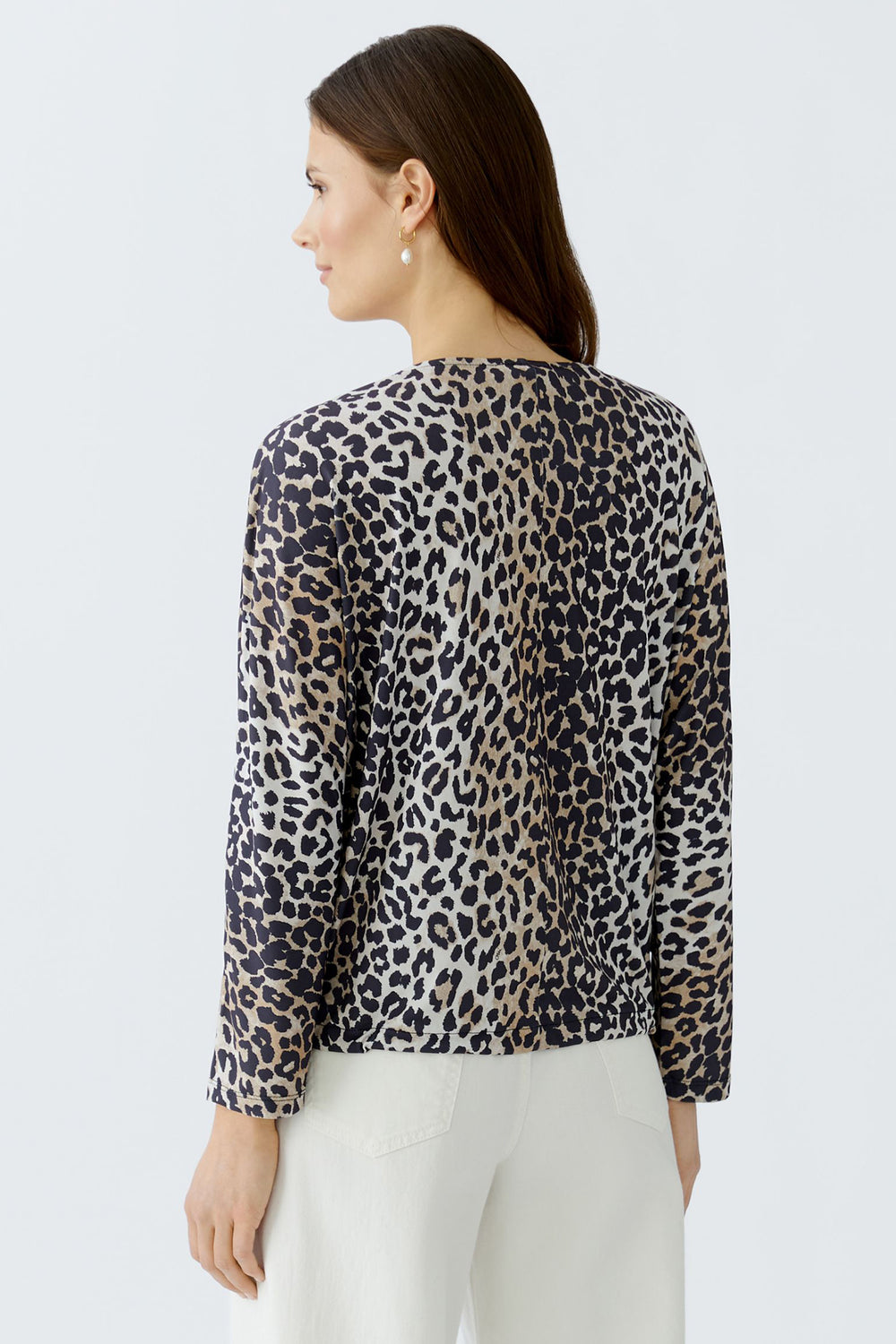 Woman wearing a leopard print blouse against a light gray background