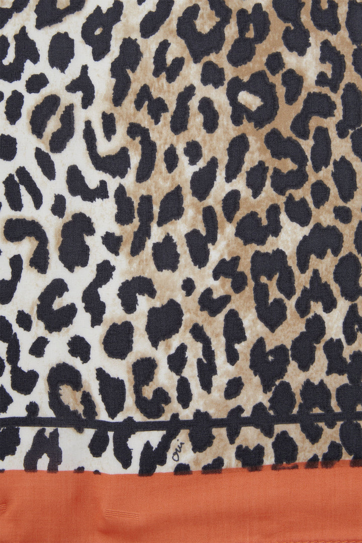Leopard print fabric with a visible brand logo on an orange background