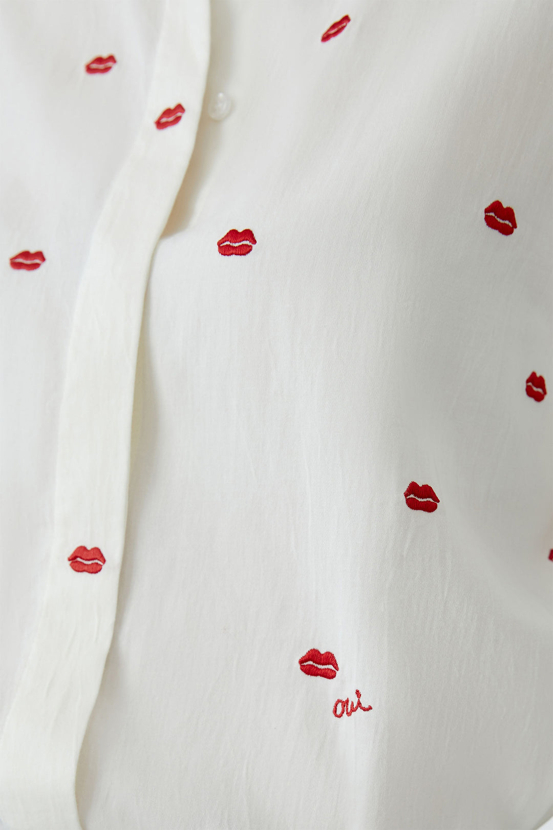 White fabric with red lip prints and ' oui' text