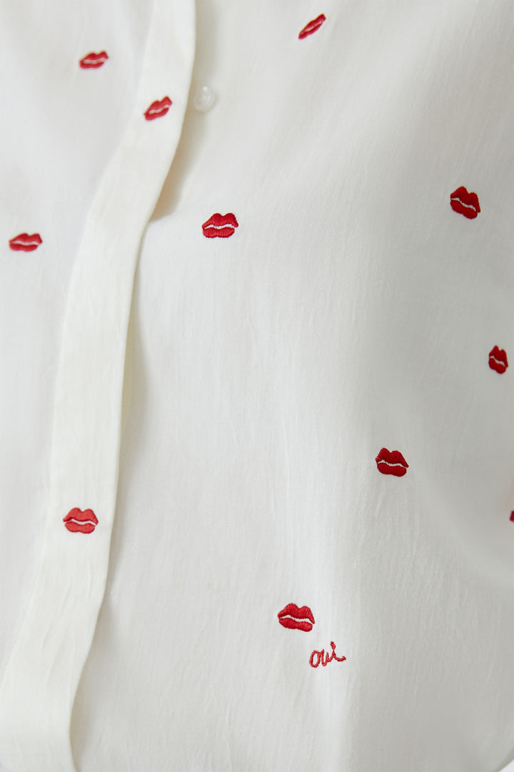 White fabric with red lip prints and ' oui' text
