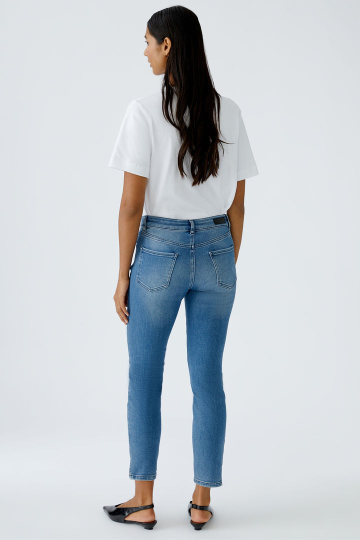 Woman wearing blue jeans and a white t-shirt on a white background