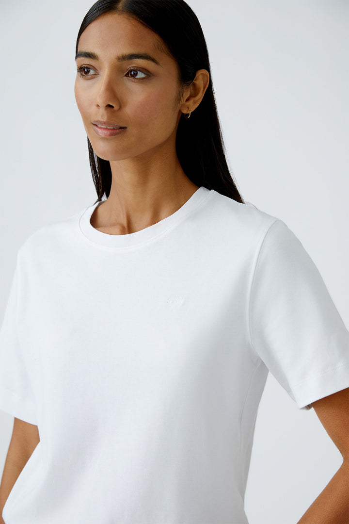 Woman wearing a plain white t-shirt against a white background