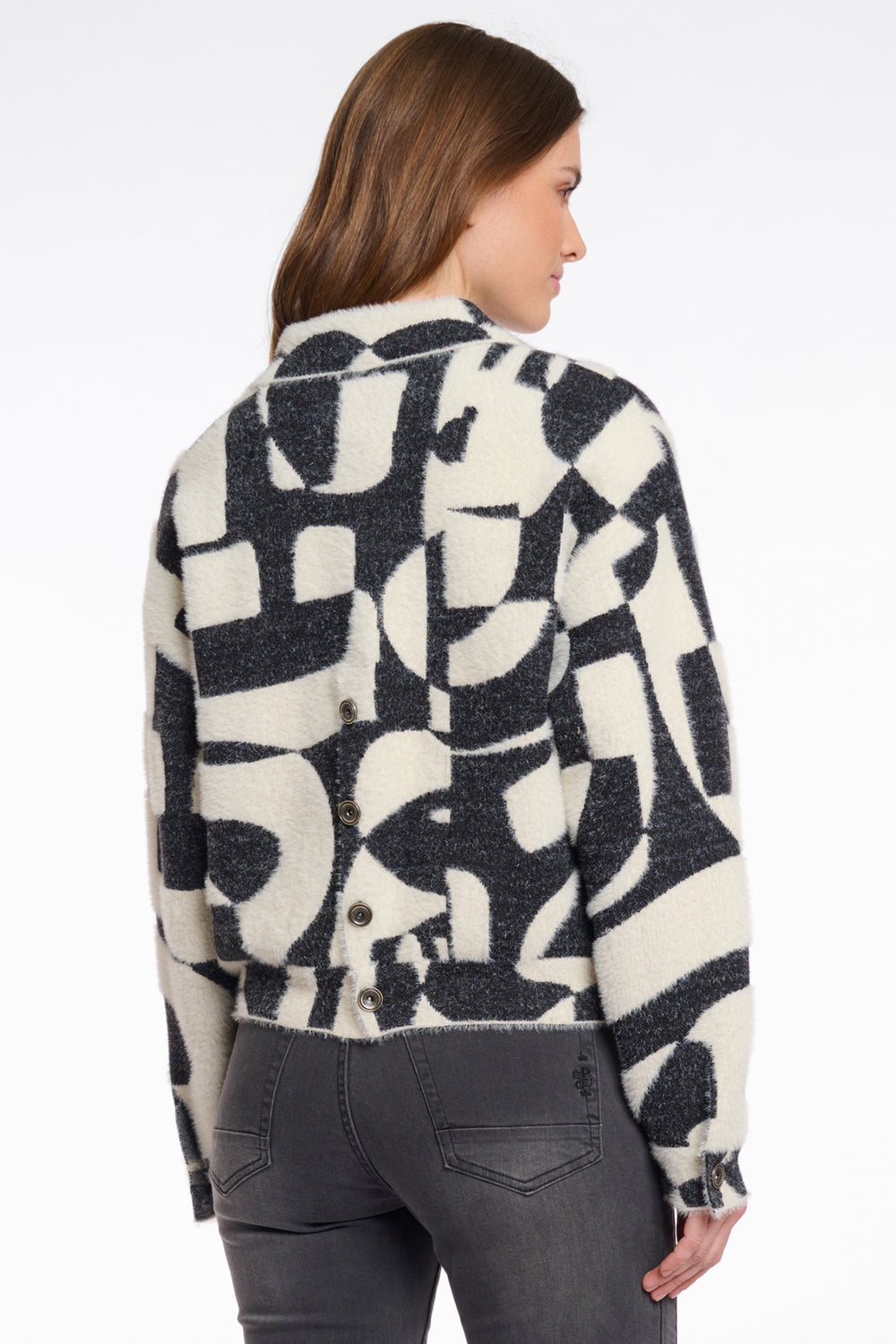 Woman wearing a patterned jacket with abstract design on a white background