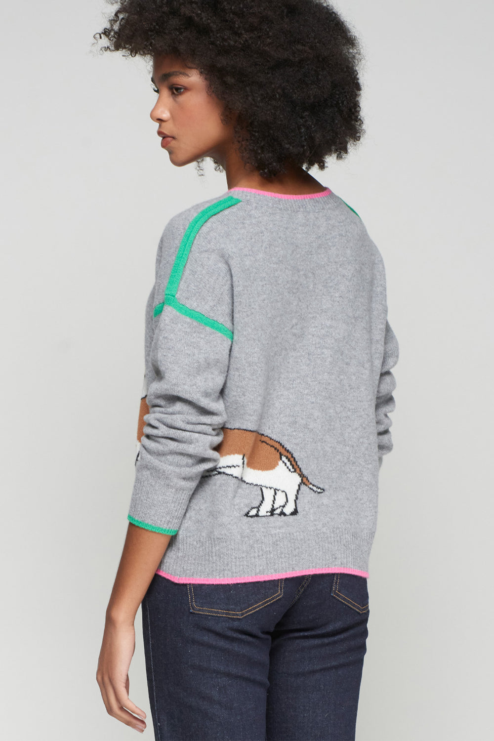 Person wearing a gray sweater with a dog graphic on a plain background