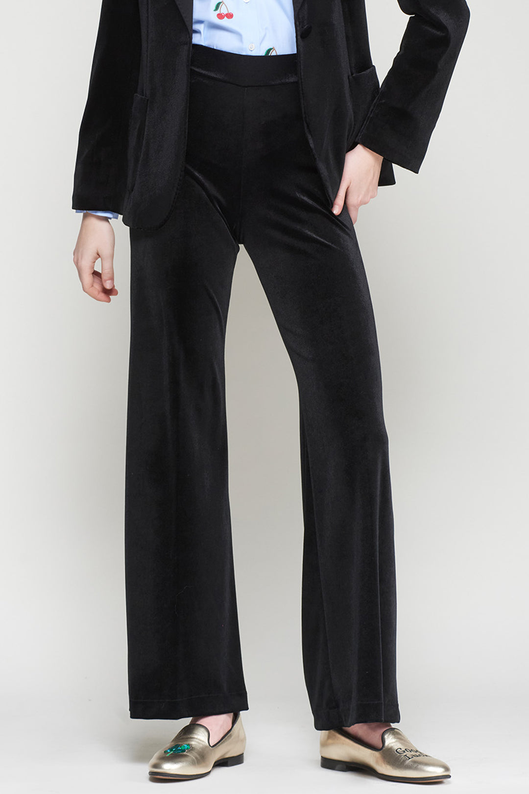 Person wearing a black suit with wide-leg pants on a white background
